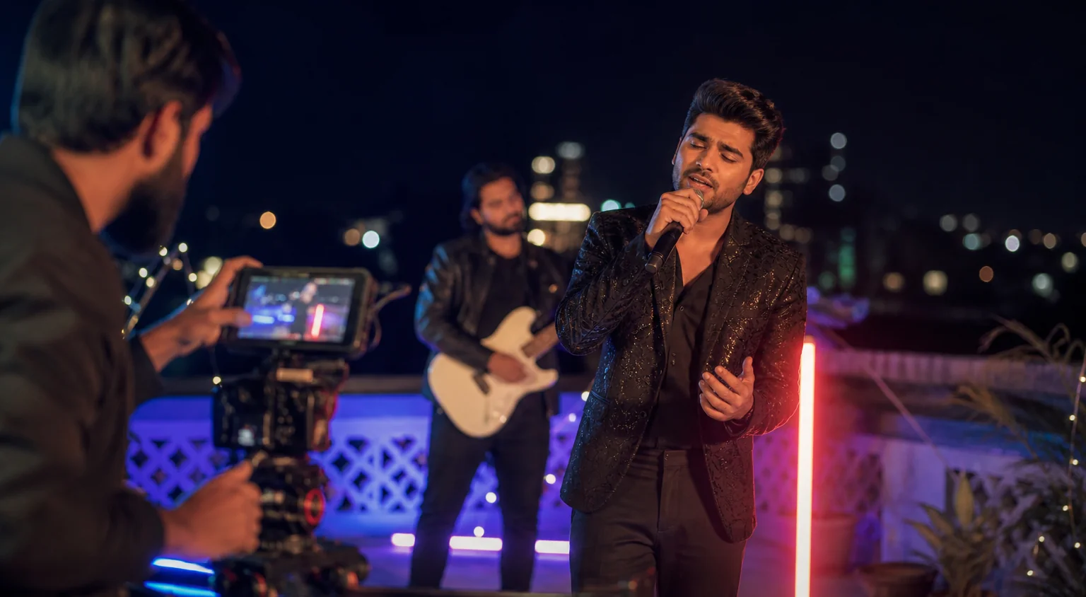 A night-time music video shoot on a rooftop with colourful lights and a camera on a slider